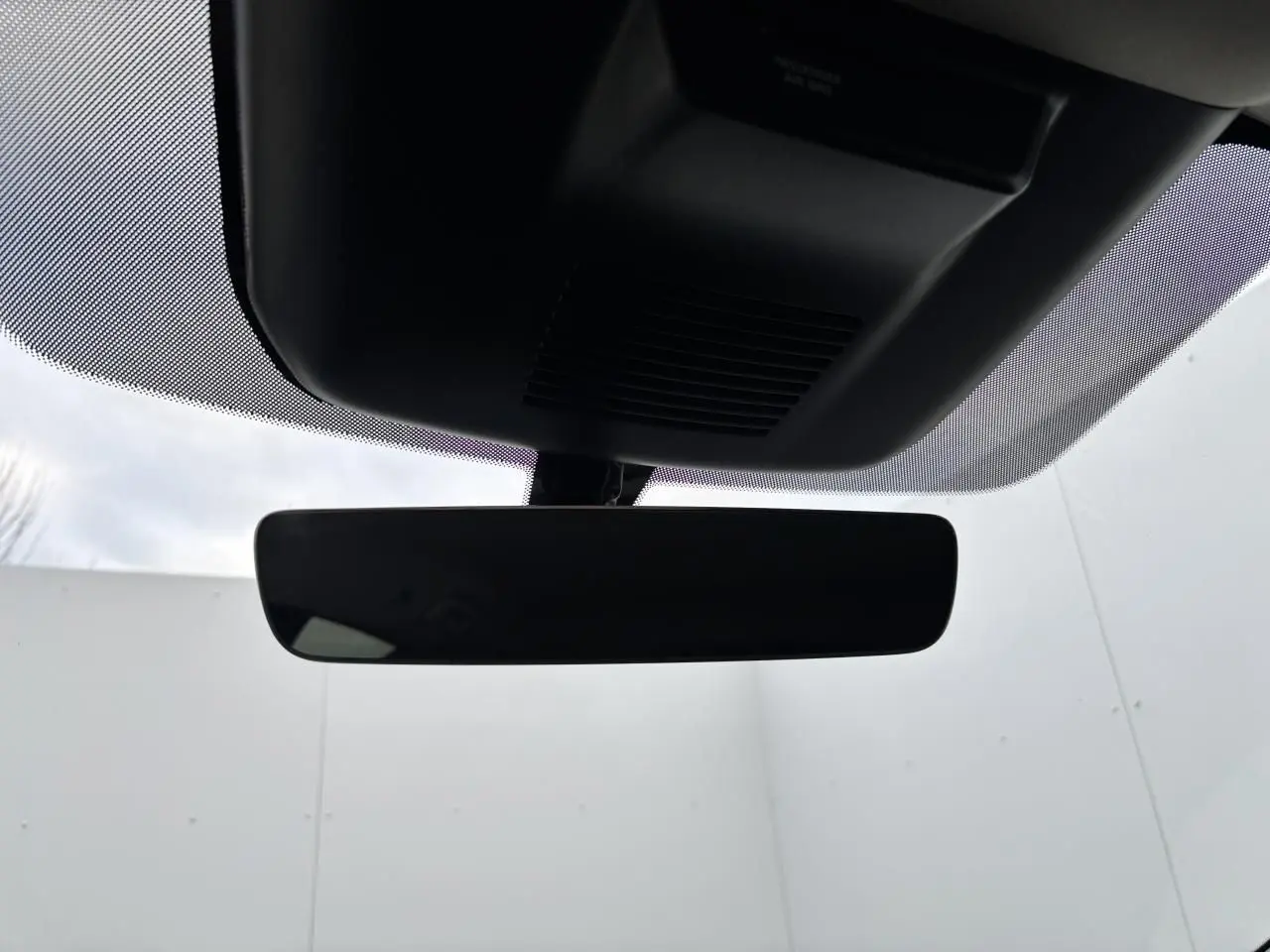 Rétroviseur intérieur noir du Nissan Qashqai blanc nacré, vue centrée depuis l'habitacle vers le pare-brise.