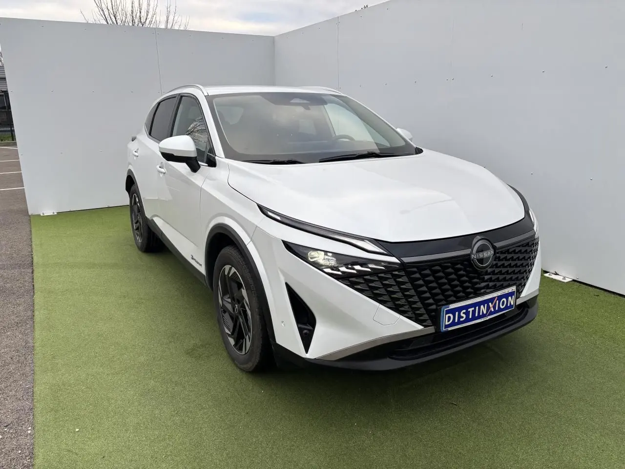 Nissan Qashqai III blanc nacré vu en 3/4 avant droit, avec calandre noire et jantes alliage 18 pouces.