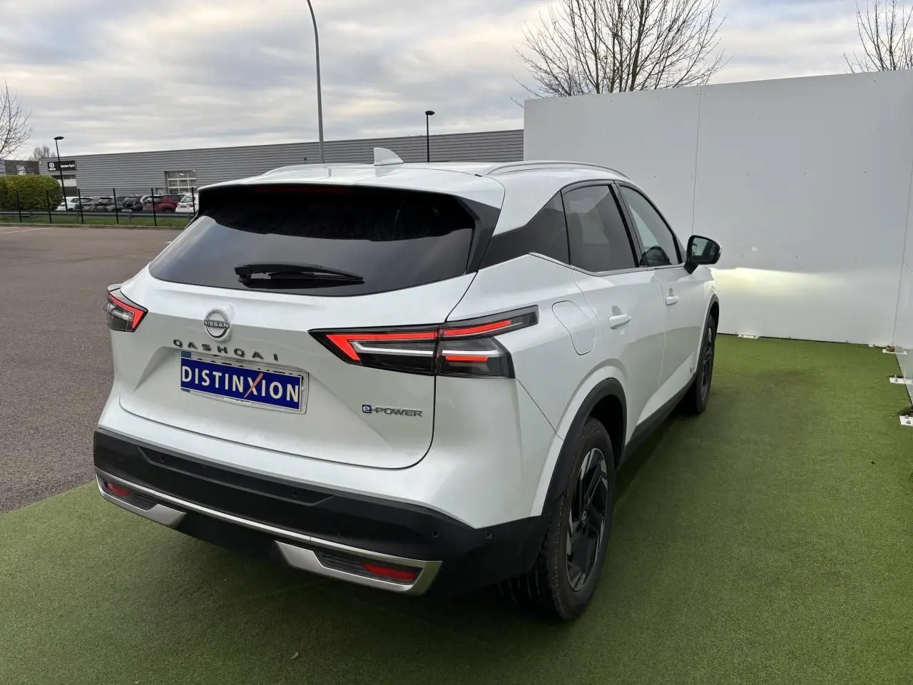 Vue 3/4 arrière droite du Nissan Qashqai blanc nacré avec feux LED et toit avec antenne aileron de requin.