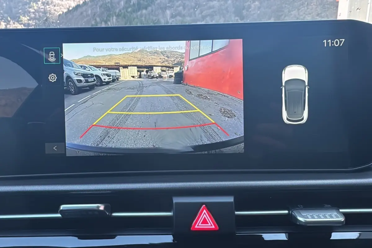 Écran multimédia affichant la caméra de recul du Kia Sportage noir étoilé avec lignes de guidage colorées.