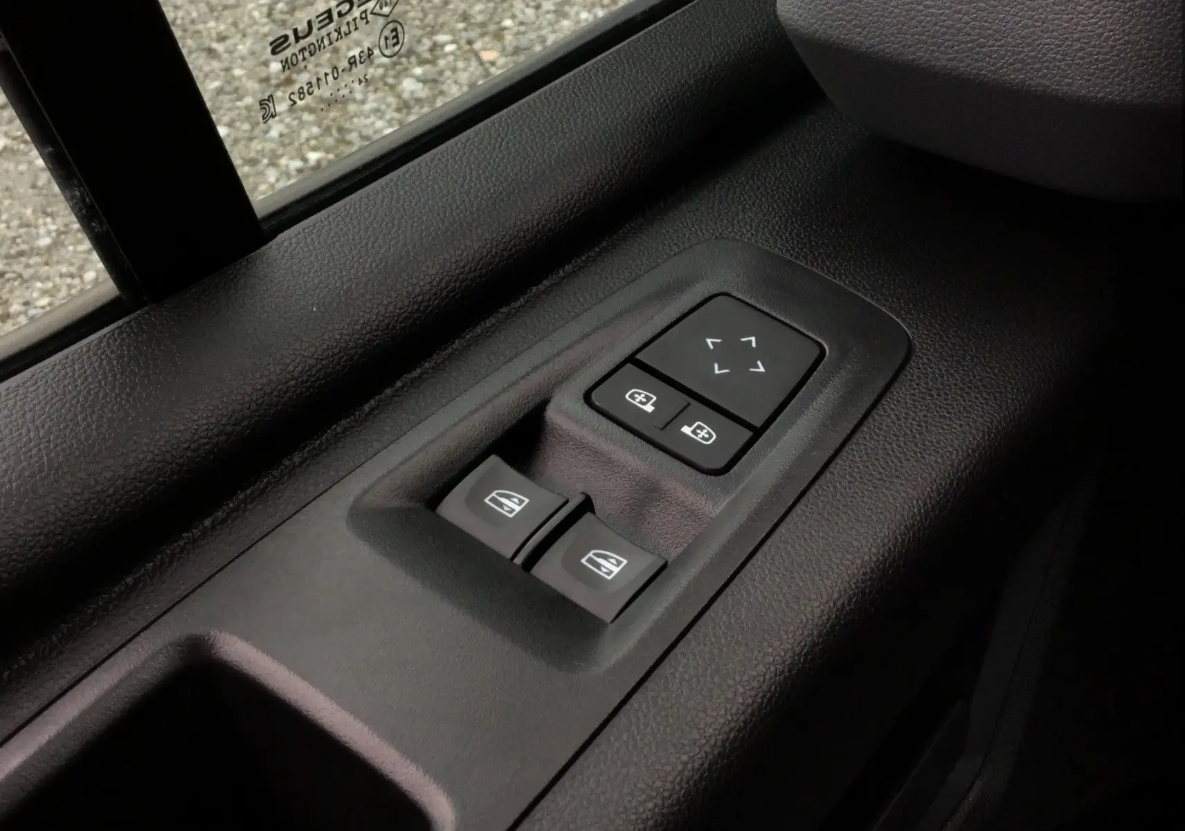Gros plan sur les commandes électriques des vitres et des rétroviseurs côté conducteur du Renault Master blanc 2025.