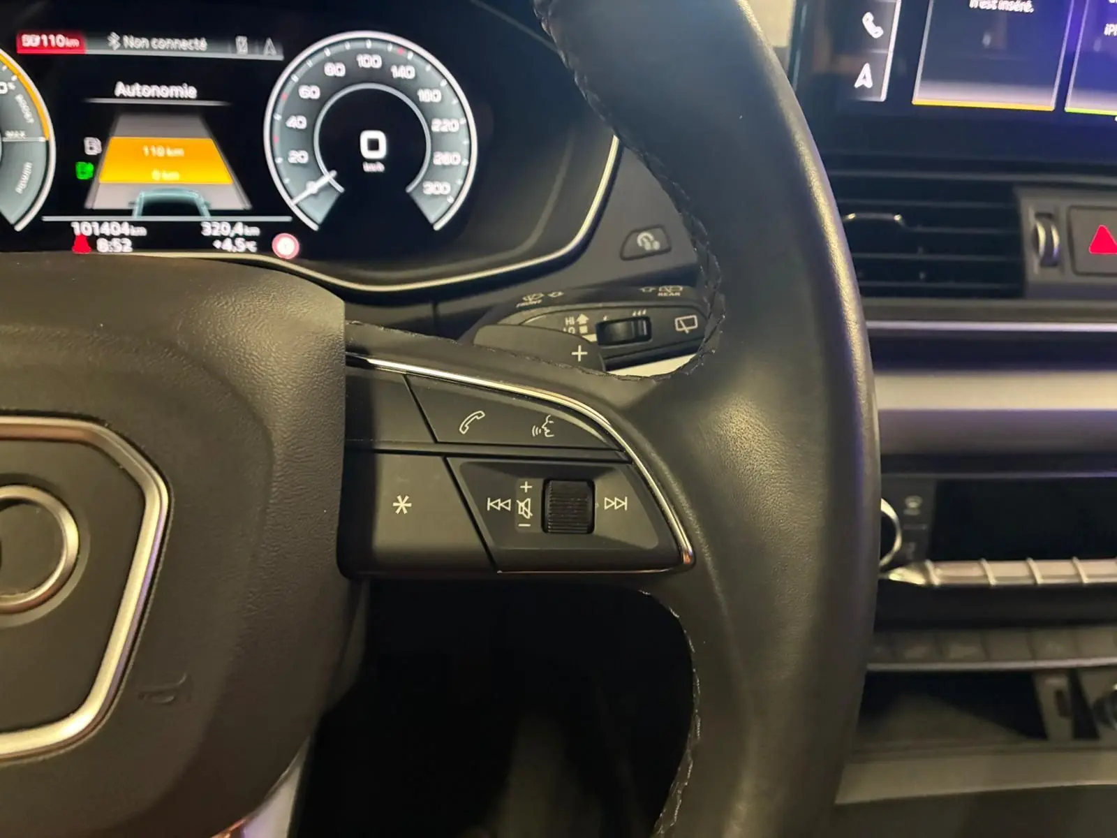 Gros plan sur le volant cuir noir d’un Audi Q5 2024 avec commandes multifonctions et tableau de bord numérique.