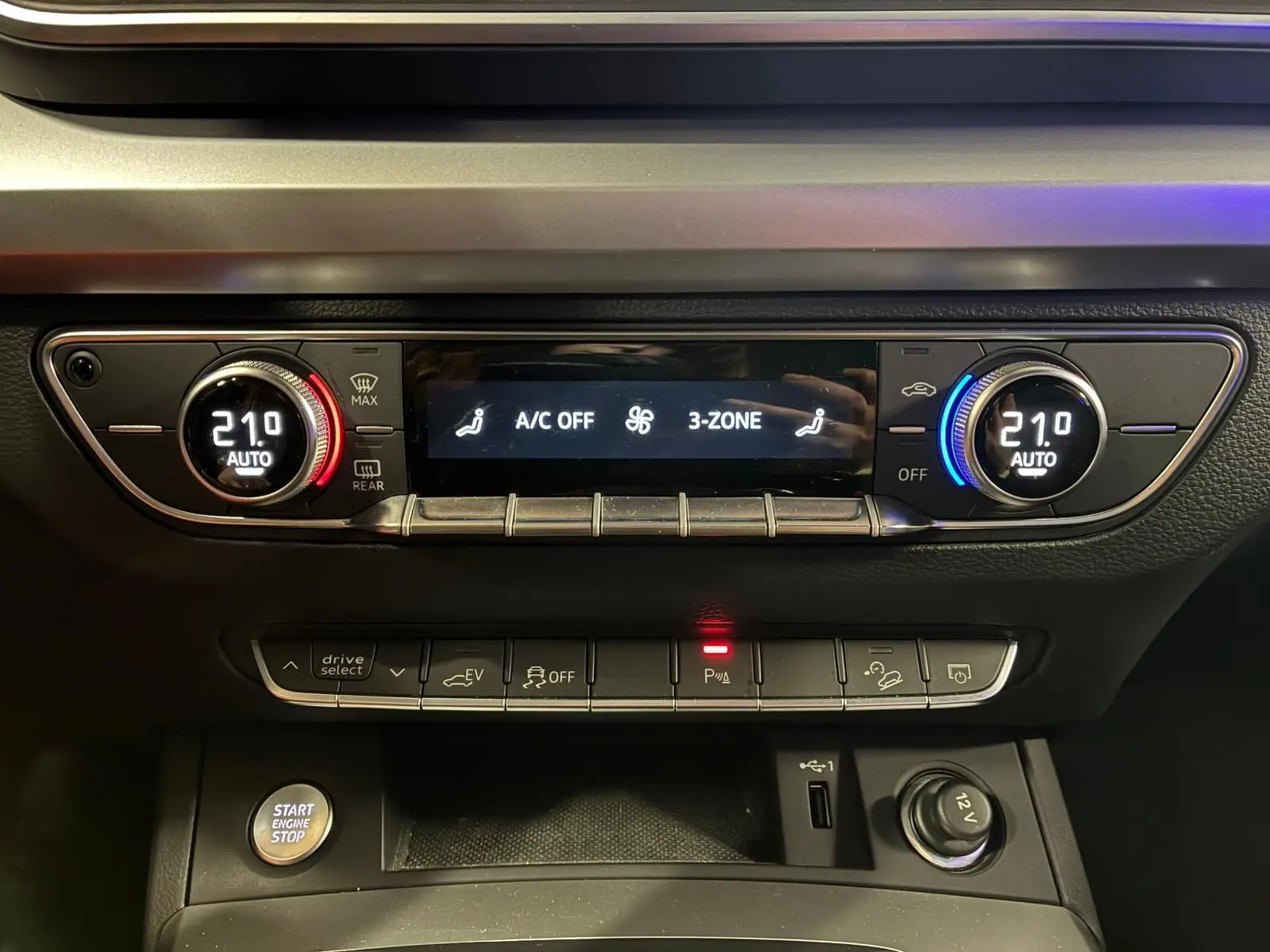 Détail du tableau de bord de l'Audi Q5 hybride 2024 montrant la climatisation automatique 3 zones à 21°C.