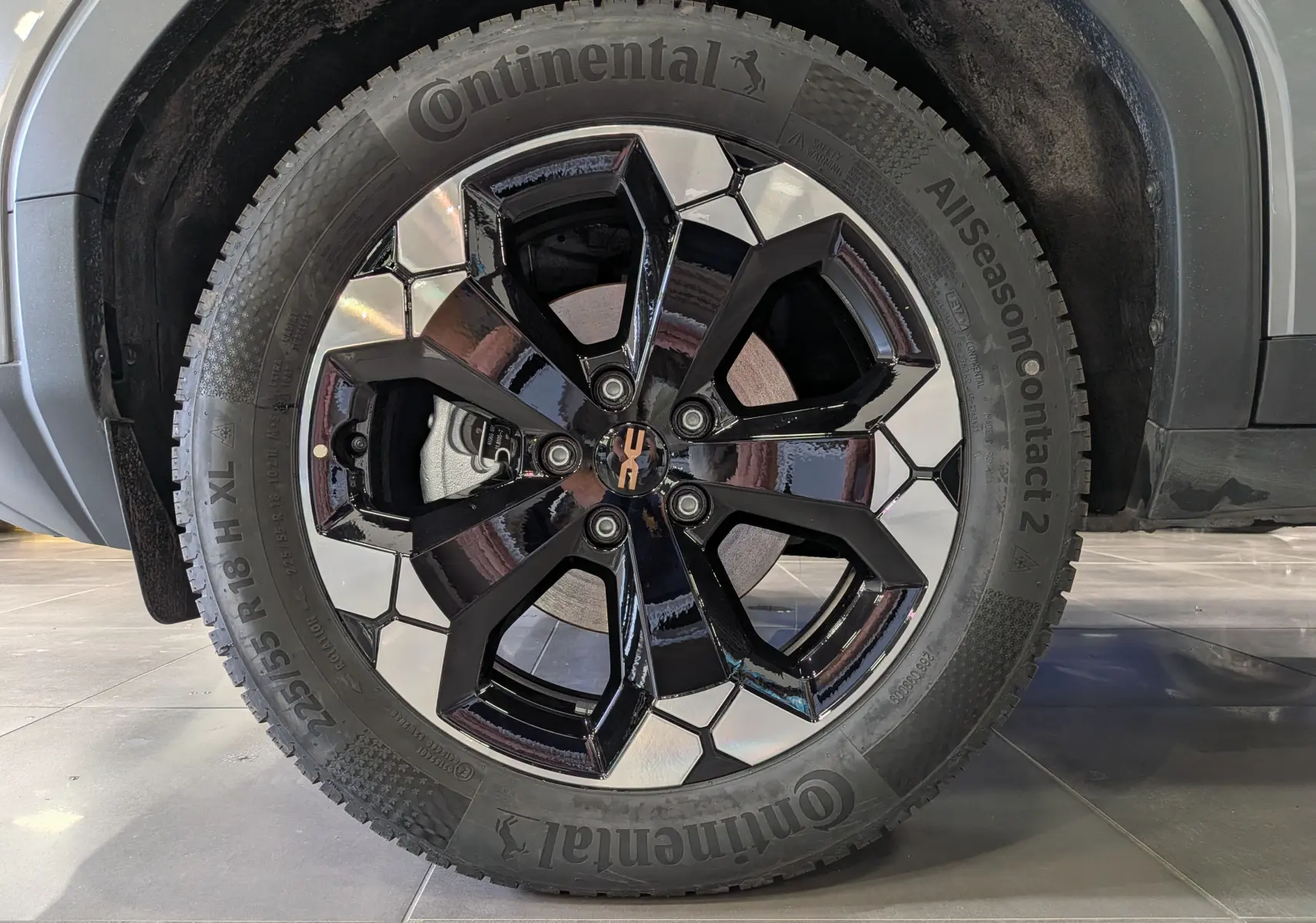 Gros plan sur la roue avant droite du Dacia Bigster gris schiste, mettant en valeur la jante noire et argentée au design moderne.