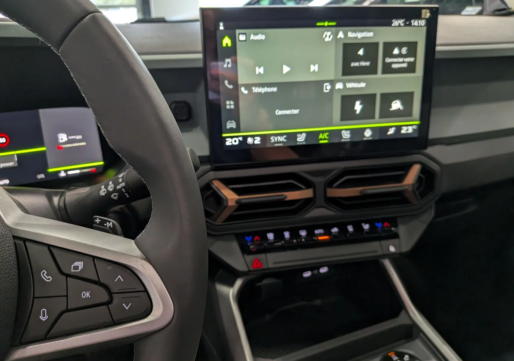 Intérieur du Dacia Bigster Hybrid-G 150 4x4 gris schiste, vue sur le volant et l’écran tactile central moderne.