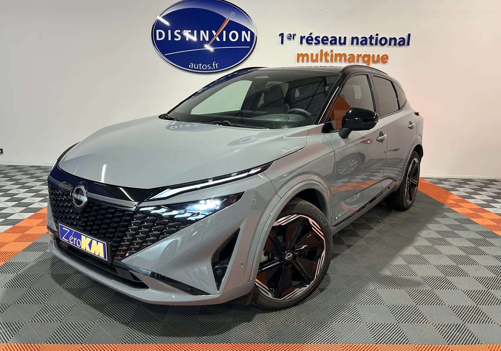 Nissan Qashqai gris céramique avec toit noir, vue 3/4 avant droit, jantes noires et calandre distinctive.