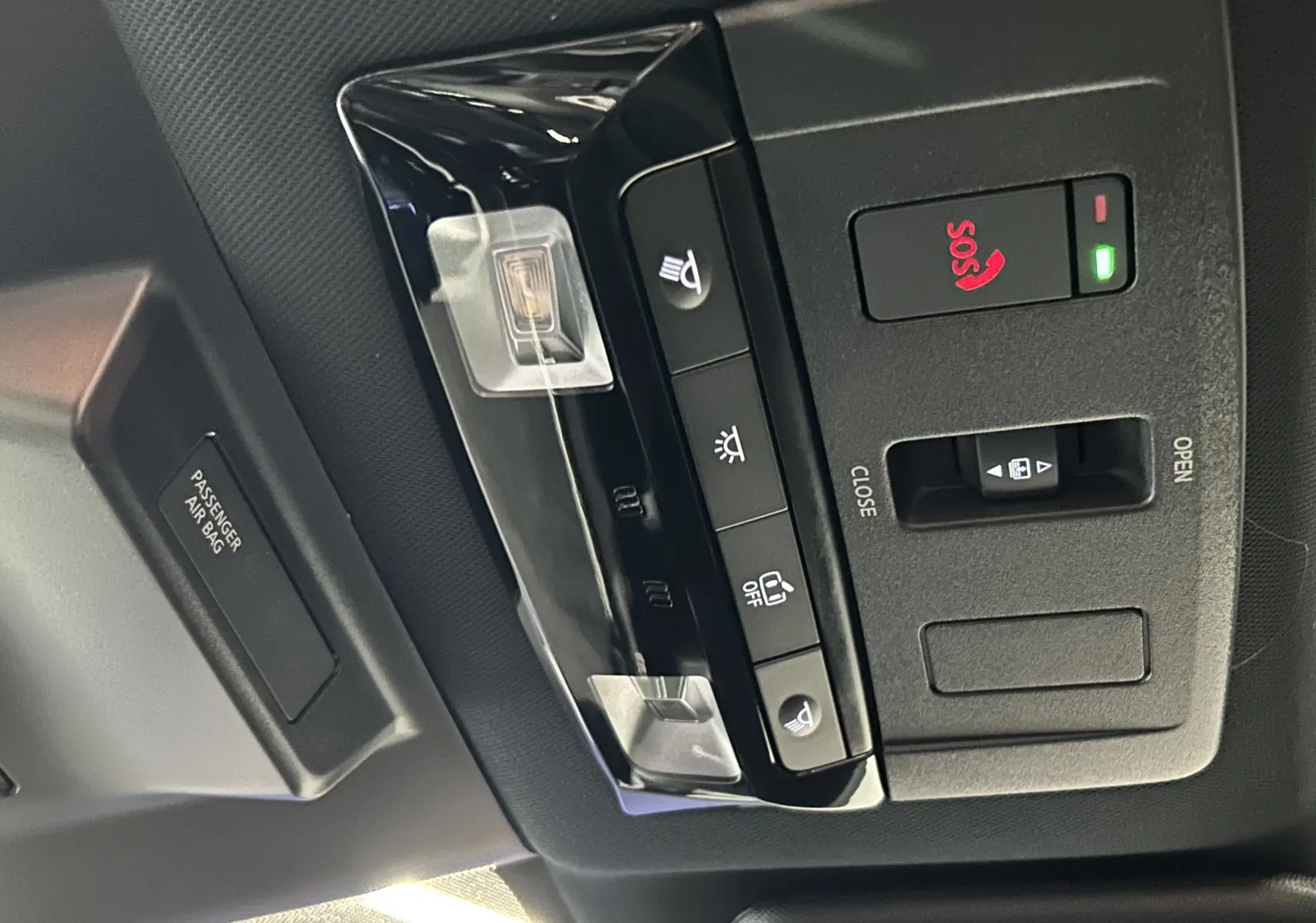 Vue en gros plan du panneau de commandes au plafond du Nissan Qashqai 2025, boutons SOS et éclairage intégrés.