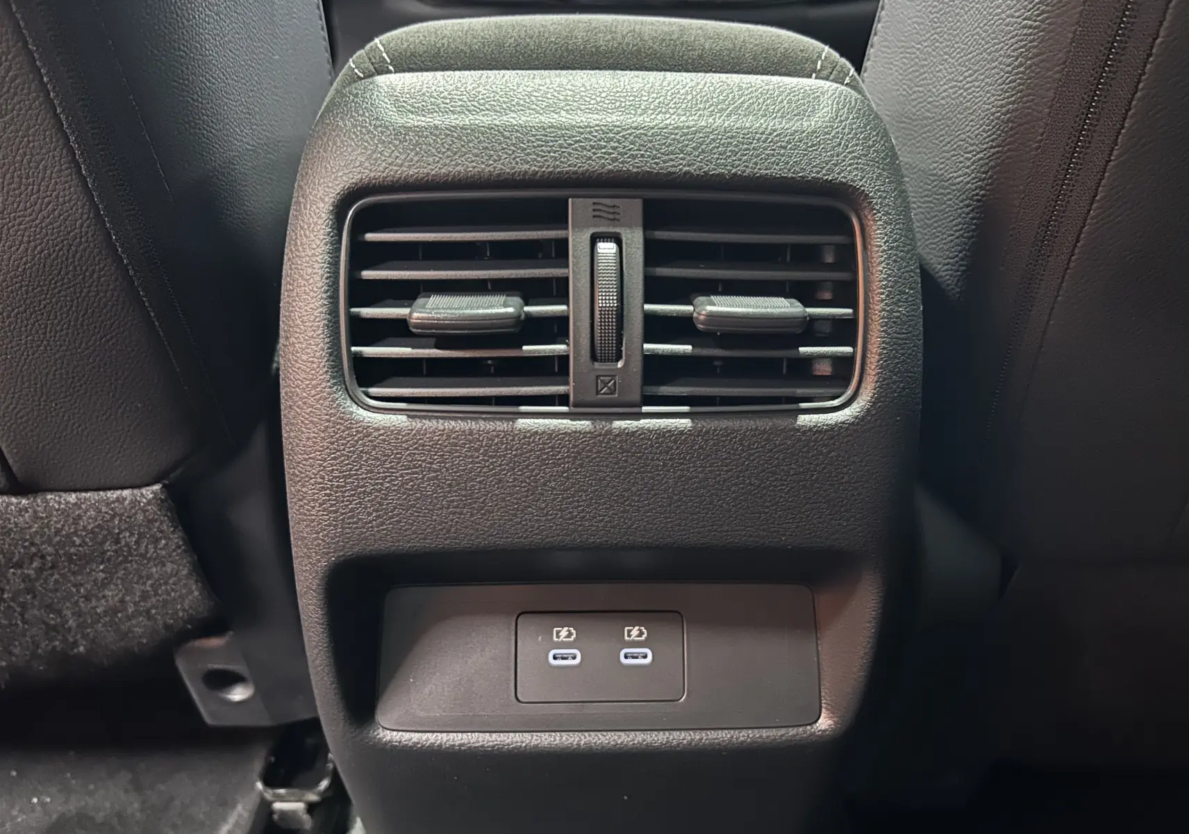 Prise USB double et sortie d'air arrière en gros plan dans l'habitacle noir du Nissan Qashqai 2025.