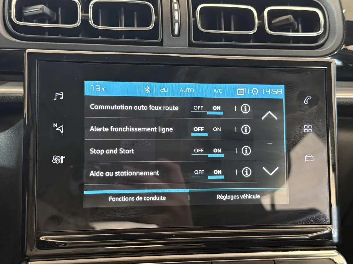 Écran tactile central affichant les réglages d’aide à la conduite dans l’habitacle d’une Citroën C3 blanche.