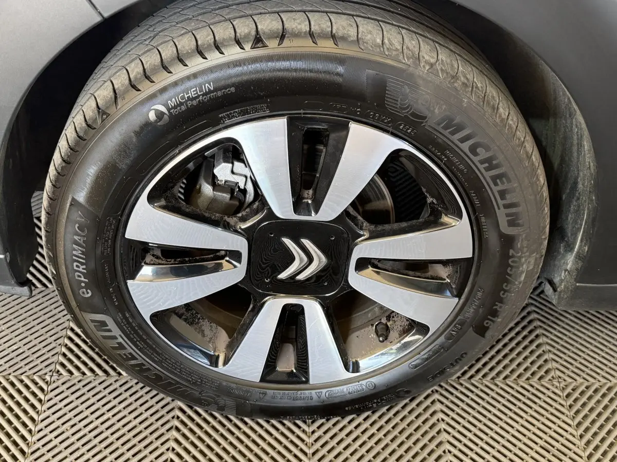 Gros plan sur la roue avant droite de la Citroën C3 blanche, jante alliage bicolore avec logo Citroën central.