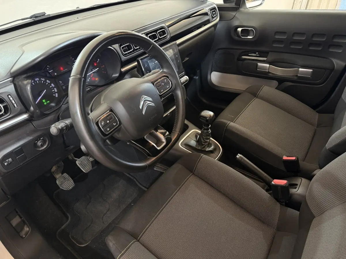 Intérieur de la Citroën C3 2021 vue côté conducteur, volant cuir multifonctions et levier de vitesse manuel visibles.