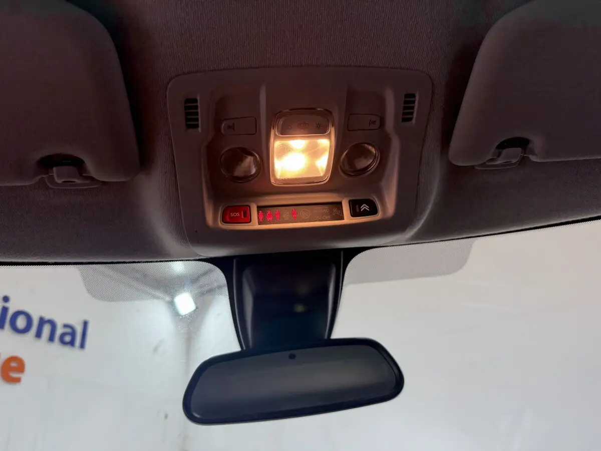 Vue intérieure du plafonnier allumé et du rétroviseur central d’une Citroën C3 blanche de 2021.