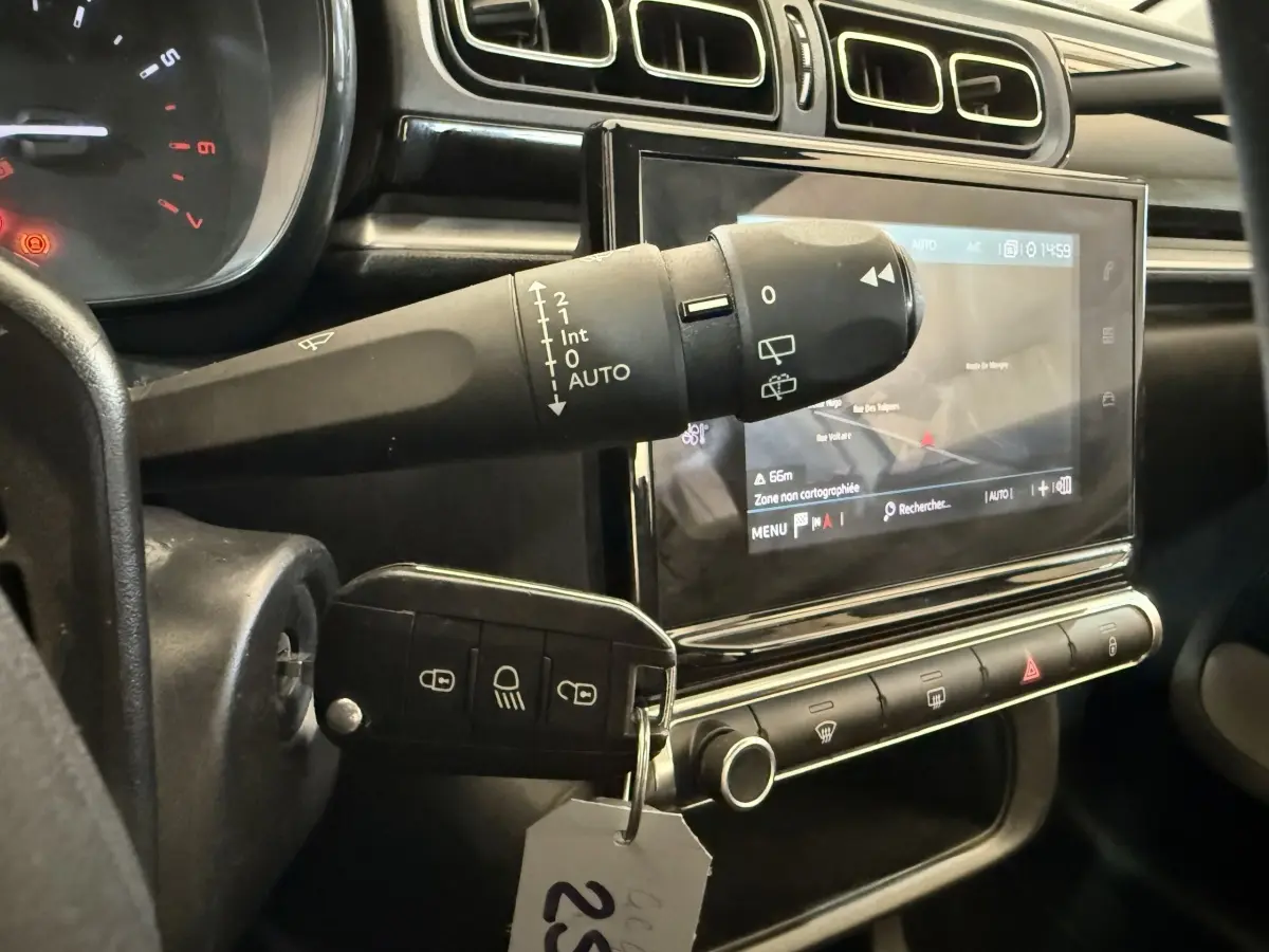 Gros plan sur le tableau de bord noir de la Citroën C3 2021, avec écran tactile et commande d’essuie-glace.