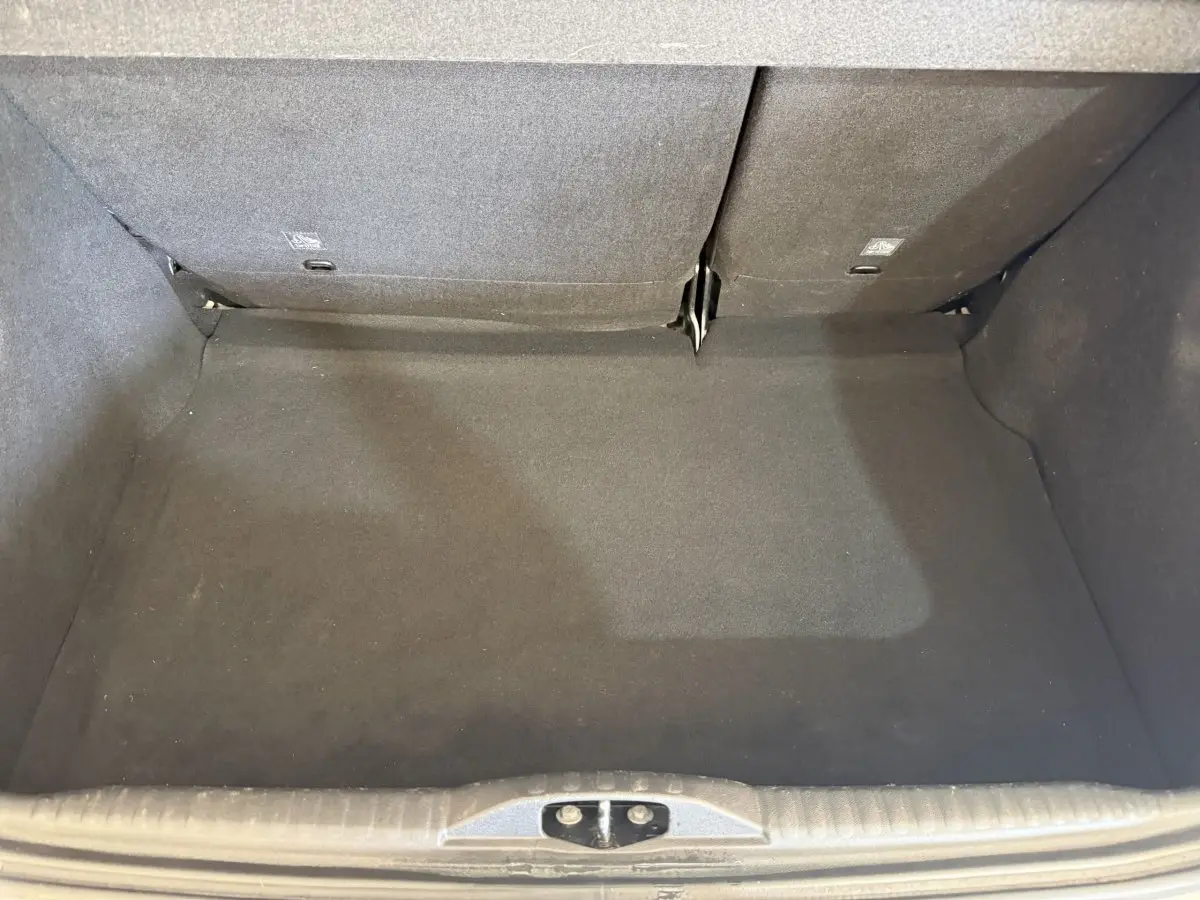 Vue intérieure du coffre spacieux de la Citroën C3 blanche, avec banquette arrière rabattue partiellement.