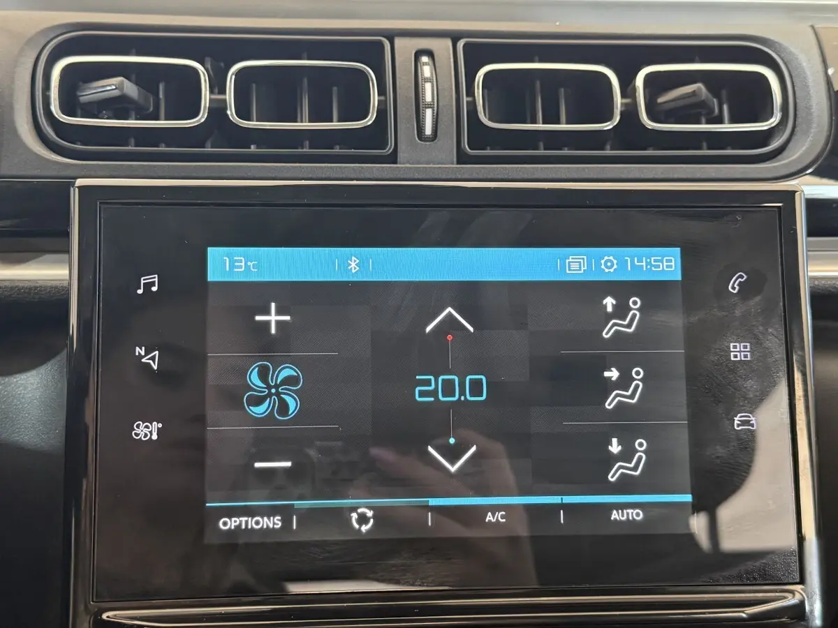 Écran tactile central de la Citroën C3 blanche, affichant la climatisation à 20°C, entouré de sorties d’air rectangulaires.