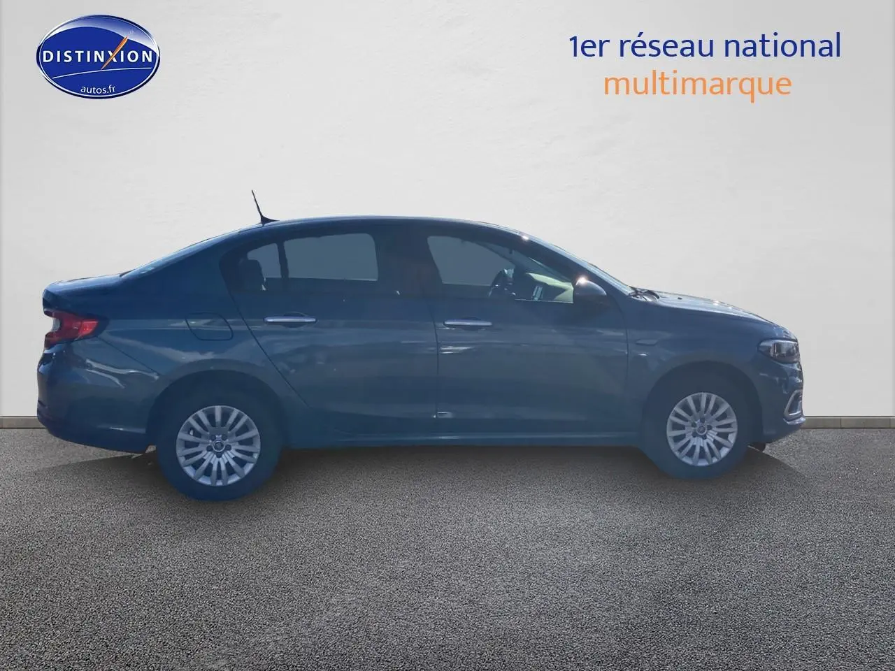 Profil latéral droit d'une Fiat Tipo bleu 2024 avec enjoliveurs et calandre chromée visible sur fond neutre.