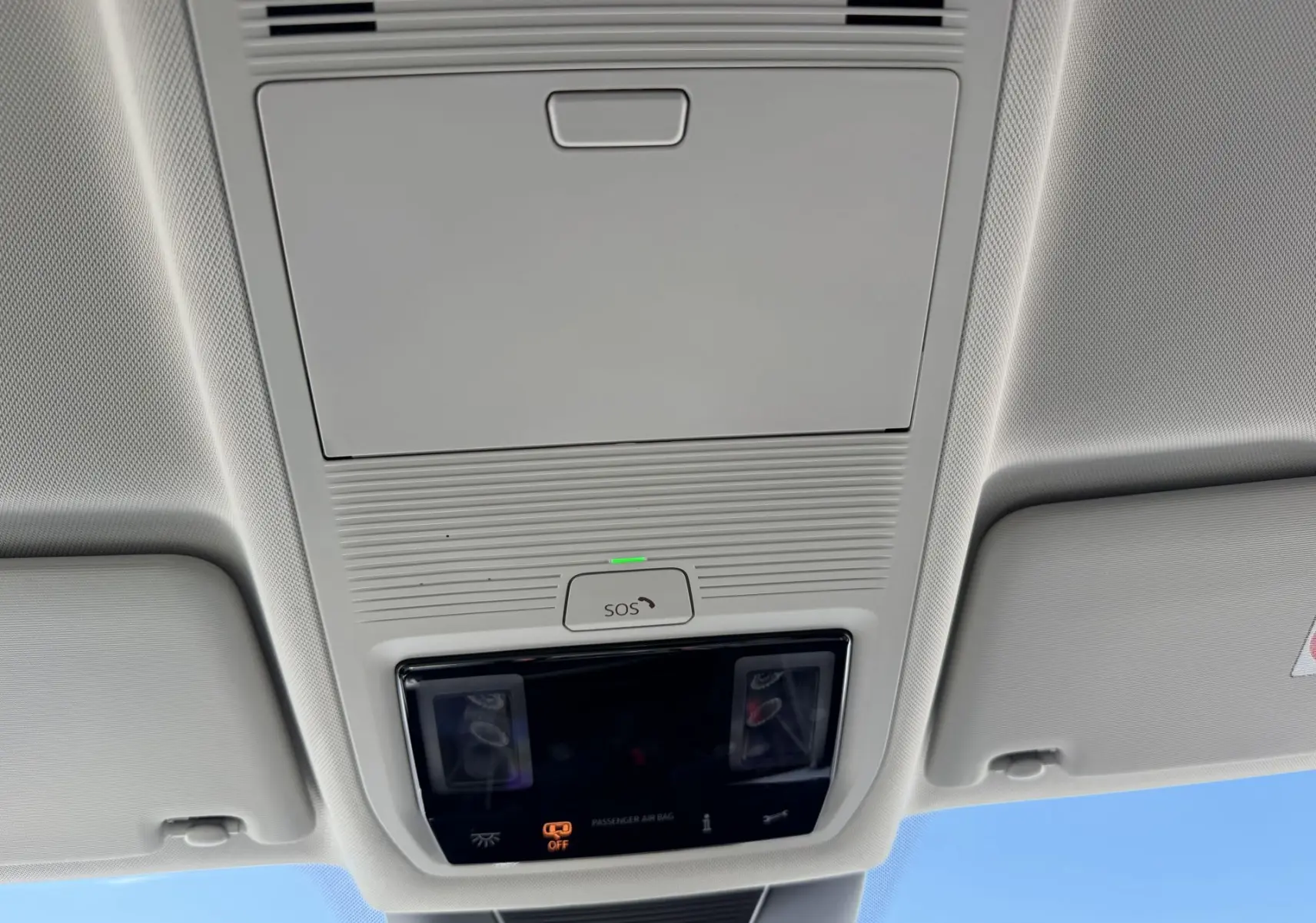 Vue intérieure du plafonnier gris clair avec commandes SOS et éclairage, dans un Volkswagen Tiguan 2025.