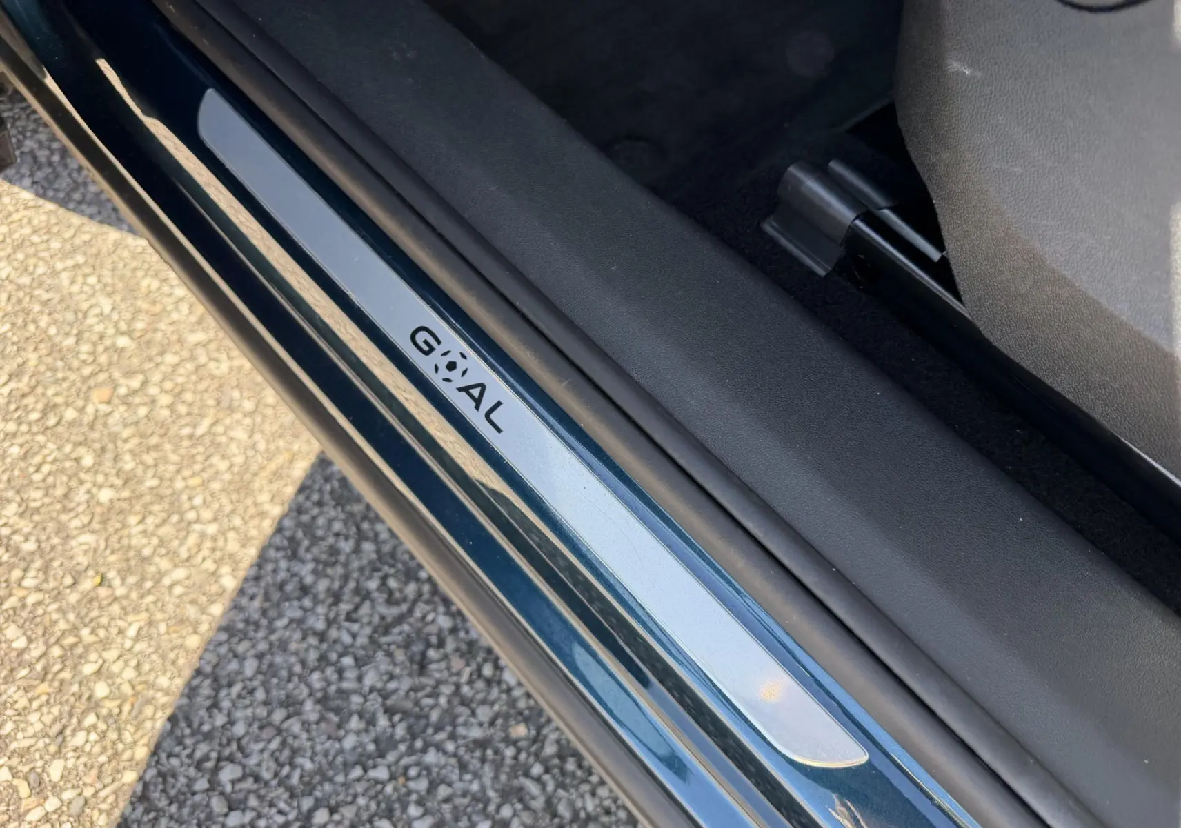 Vue rapprochée de la porte côté conducteur du Volkswagen Tiguan bleu avec seuil de porte marqué GOAL.