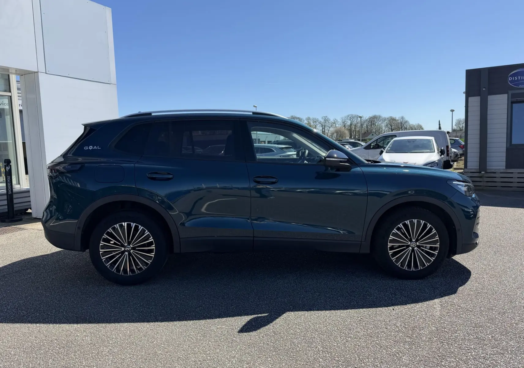 Vue latérale droite d'un Volkswagen Tiguan bleu 2025 avec jantes alliage 18 pouces et vitres teintées.