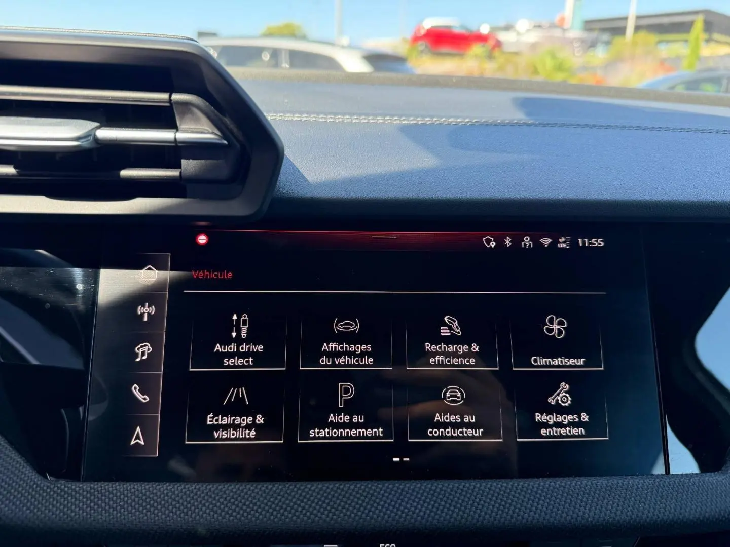 Vue intérieure du tableau de bord de l'Audi A3 Sportback 2025 avec écran multifonction affichant les réglages du véhicule.