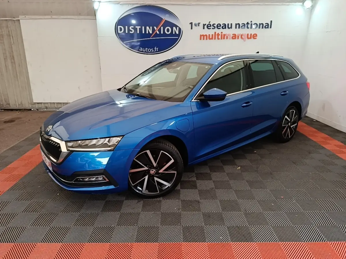 Vue 3/4 avant droite d'une Skoda Octavia Style hybride rechargeable bleu métallisé avec jantes noires et grises.