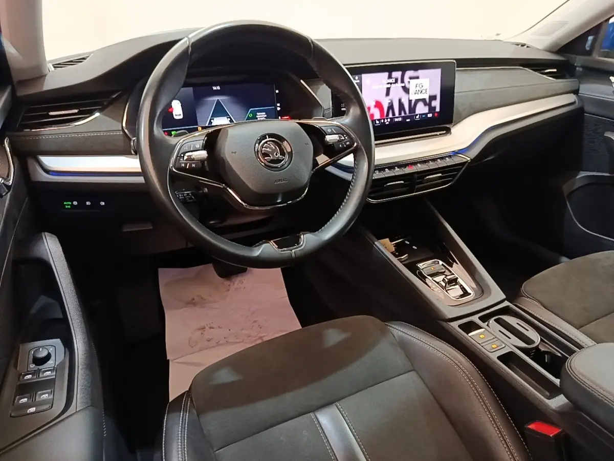 Vue intérieure avant droite du poste de conduite de la Skoda Octavia hybride rechargeable avec volant cuir et écran tactile central.
