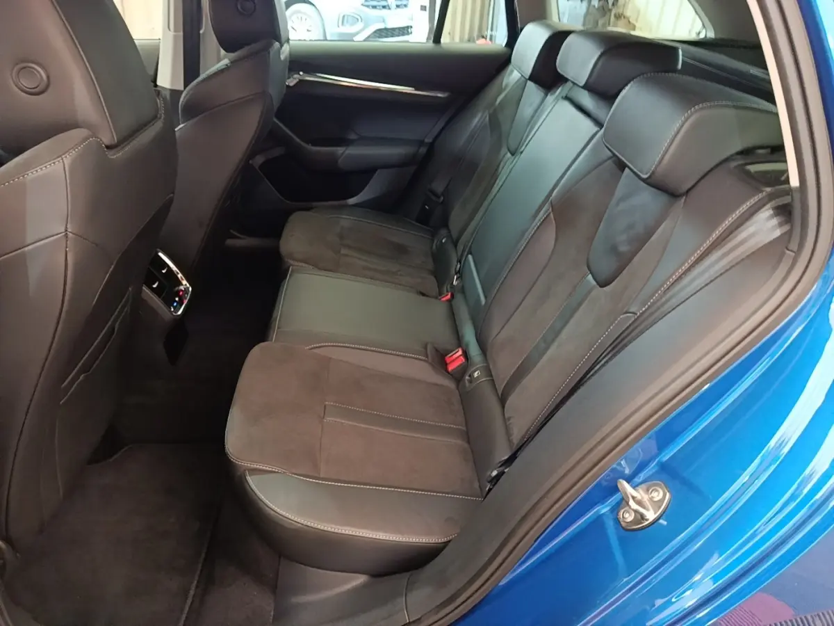 Vue côté droit de la banquette arrière en cuir et alcantara d'une Skoda Octavia bleu 2022, porte ouverte.