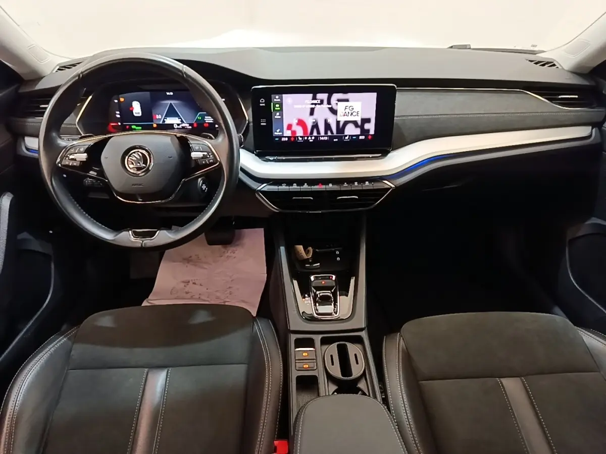 Intérieur de la Skoda Octavia 2022, vue de face sur le tableau de bord et volant cuir noir avec écran tactile central.