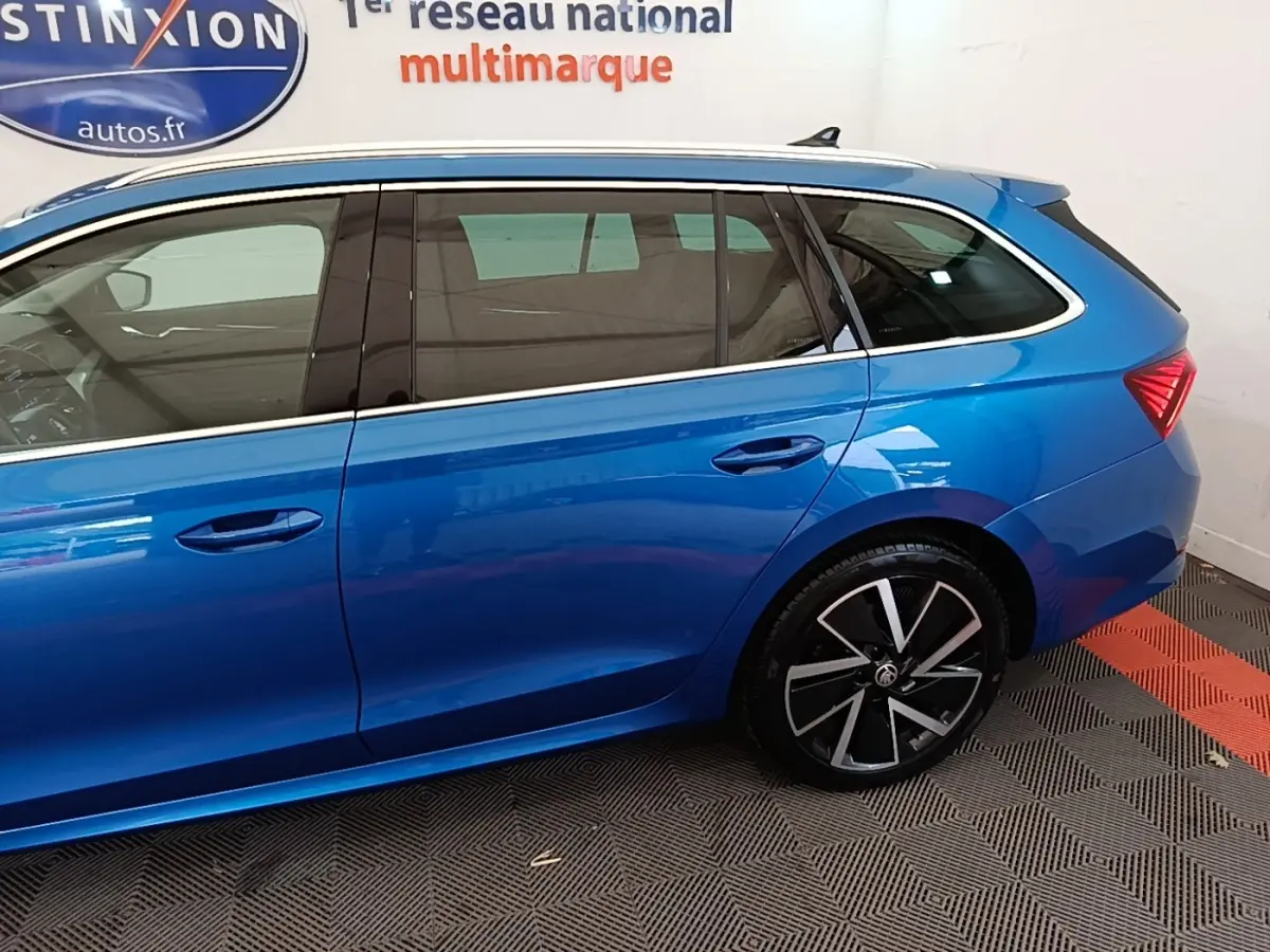 Vue latérale gauche d'une Skoda Octavia bleue 2022, mettant en valeur les jantes noires et les vitres teintées.