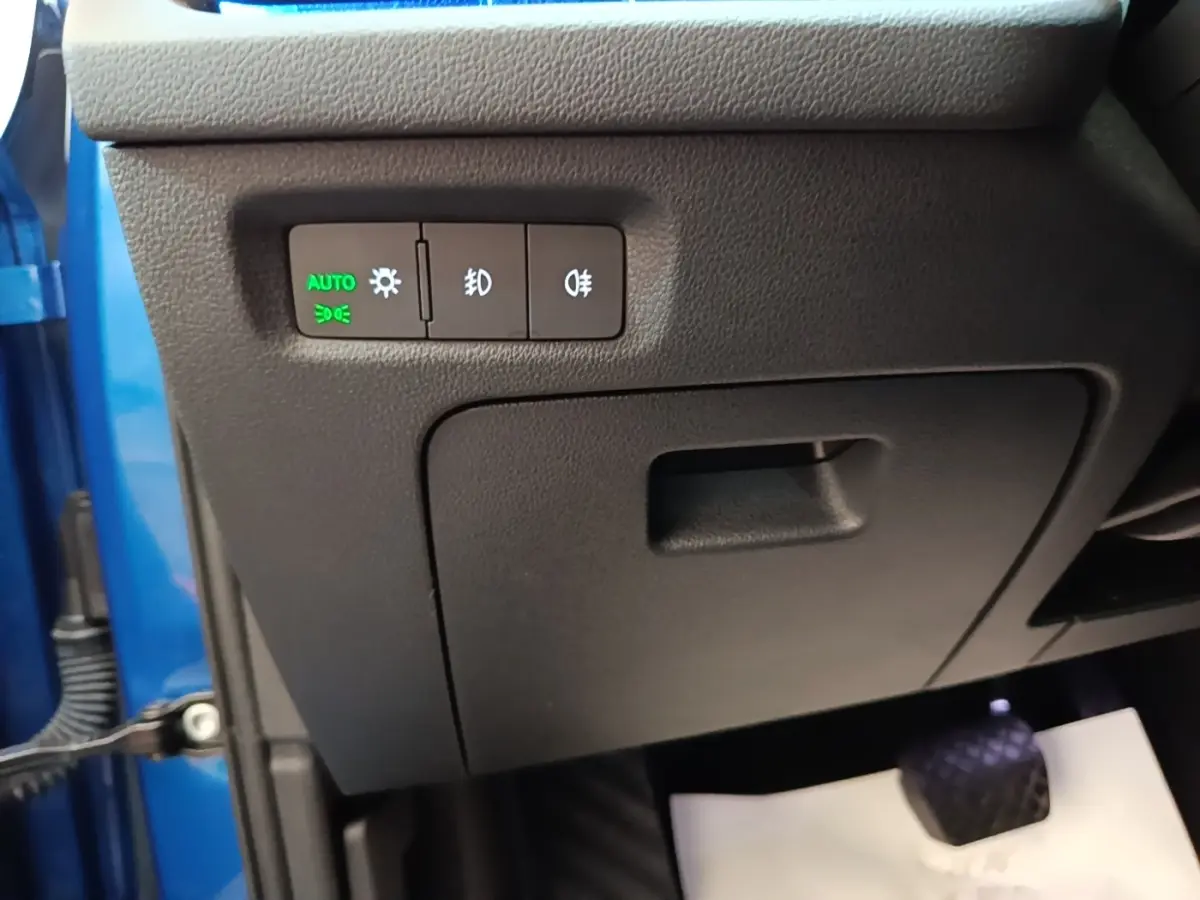Détail du panneau de commande des phares à gauche du volant dans une Skoda Octavia bleue 2022, version hybride rechargeable.
