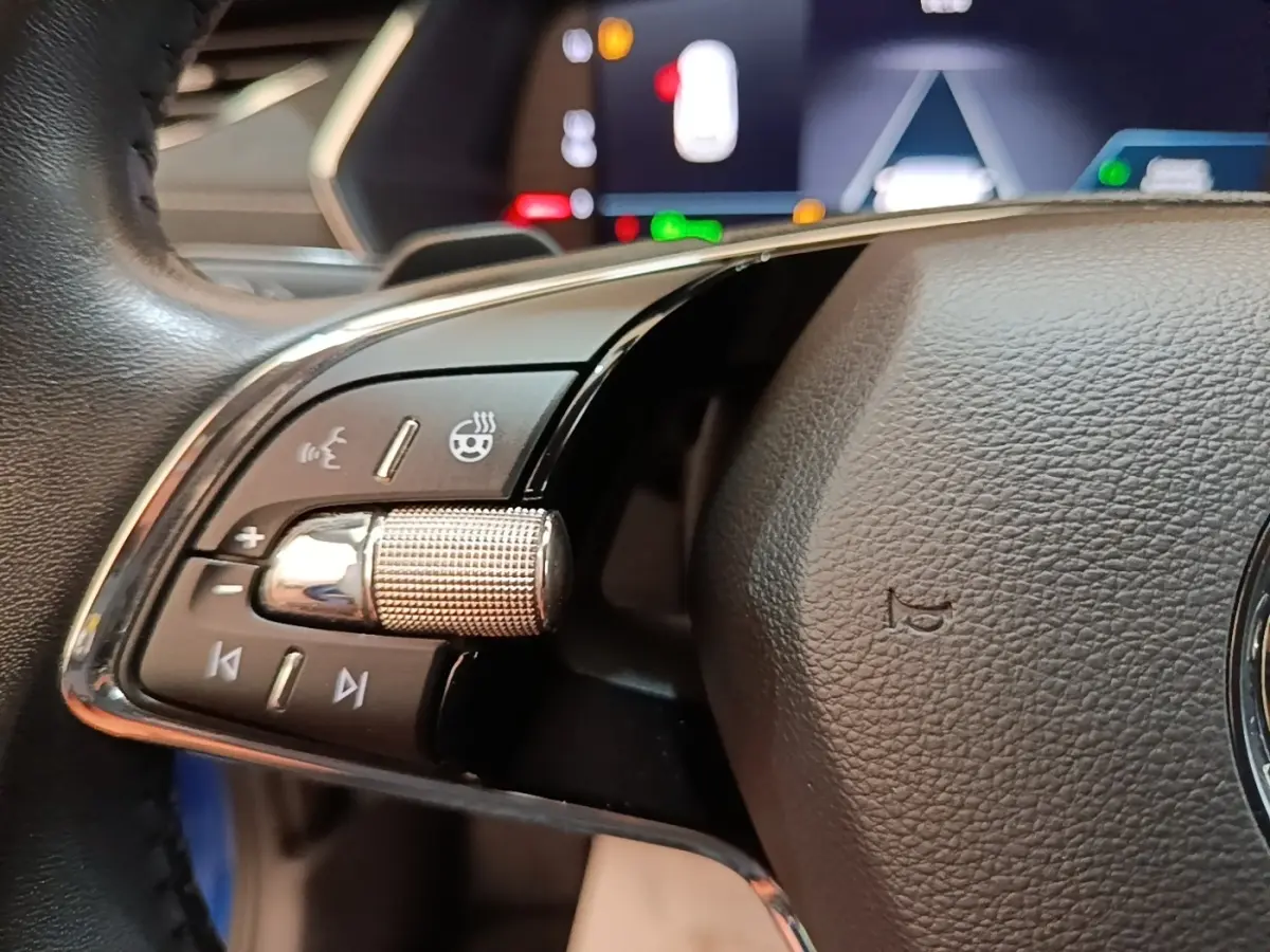 Gros plan sur le volant cuir noir de la Skoda Octavia 2022, avec commandes multifonctions et affichage numérique en arrière-plan.