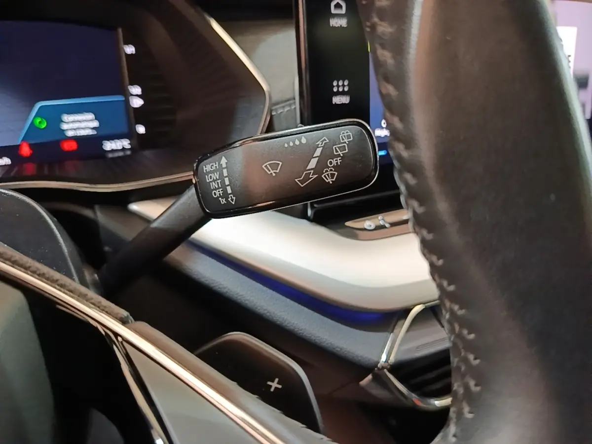 Gros plan sur la commande d’essuie-glace à gauche du volant cuir noir dans l’habitacle de la Skoda Octavia bleue.