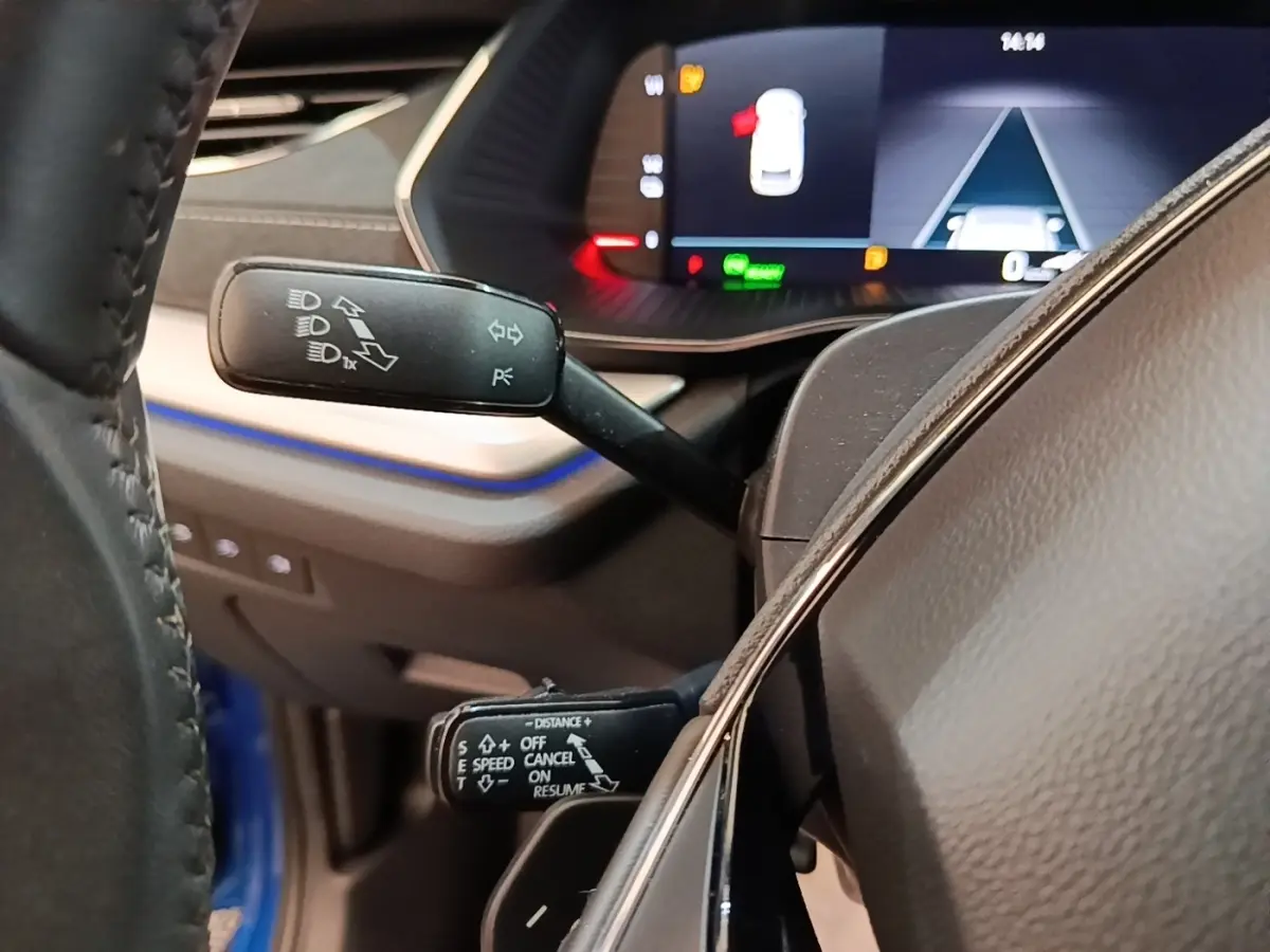 Gros plan sur les commandes au volant d’une Skoda Octavia 1.4 TSI PHEV 2022, intérieur avec tableau de bord numérique.