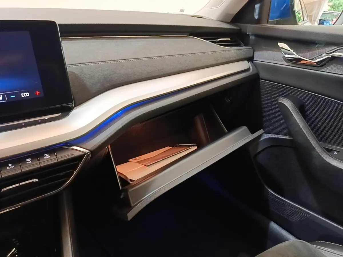 Intérieur de la Skoda Octavia 1.4 TSI PHEV 2022, vue côté passager sur la boîte à gants ouverte et tableau de bord noir.