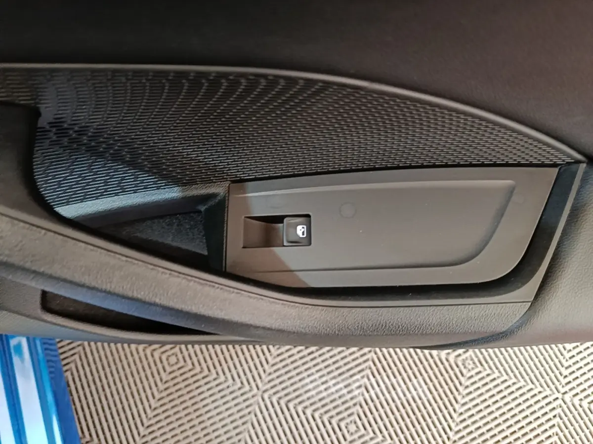Détail de la commande de verrouillage sur la porte intérieure côté conducteur d’une Skoda Octavia bleue 2022.