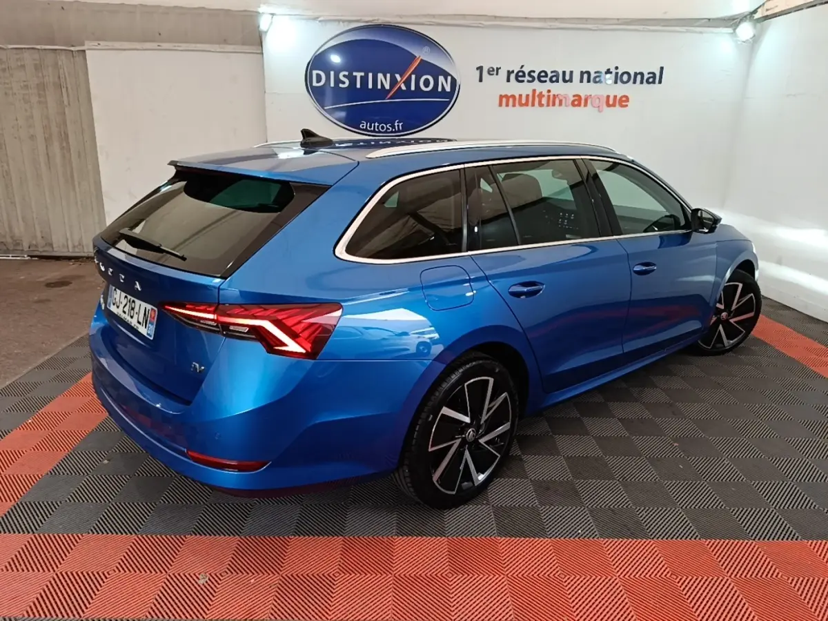 Vue 3/4 arrière droite d'une Skoda Octavia bleue hybride rechargeable, avec jantes noires et feux LED distinctifs.