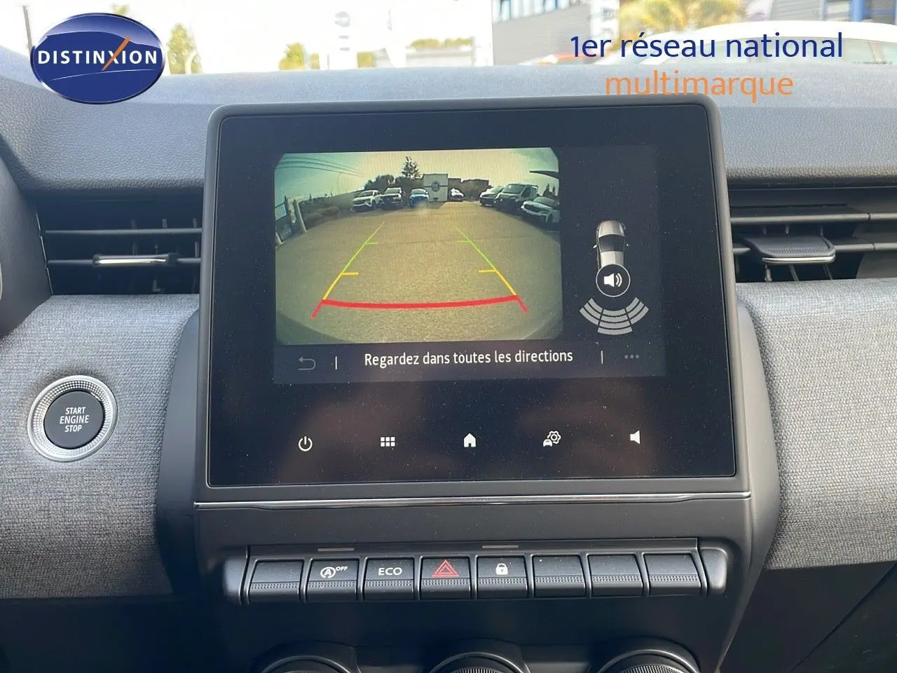 Écran central affichant la caméra de recul d'une Renault Clio gris schiste, vue intérieure du tableau de bord.