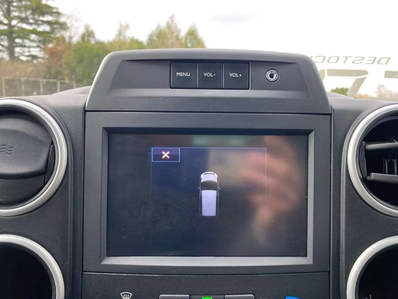 Écran tactile central du Peugeot Partner gris Artense 2017 affichant une vue de dessus du véhicule en stationnement.