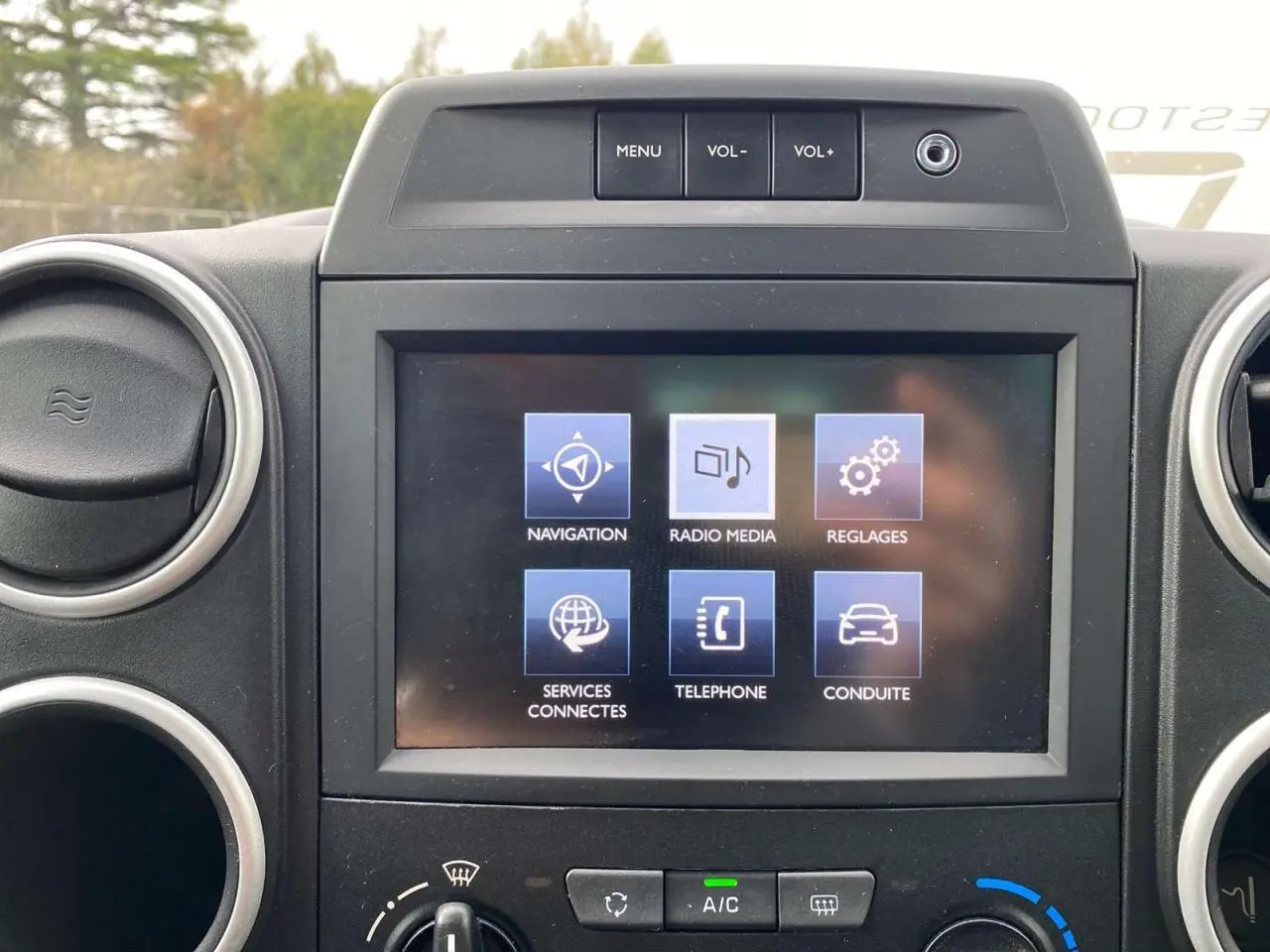Écran tactile multifonctions du tableau de bord du Peugeot Partner TEPEE Active gris, avec commandes de navigation et média visibles.
