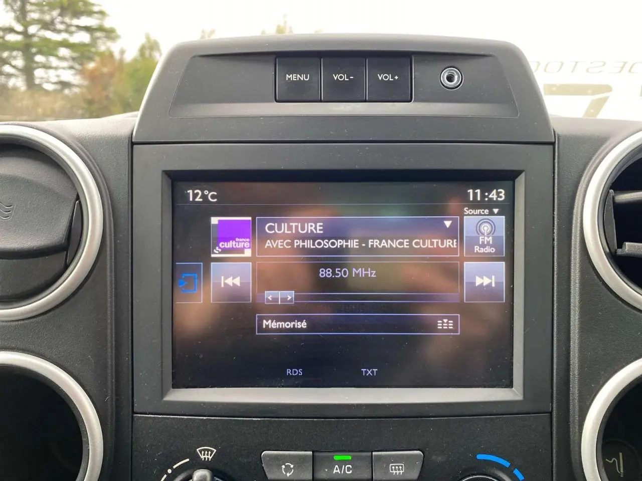 Écran tactile 7 pouces affichant radio FM dans l'habitacle du Peugeot Partner gris Artense 2017.