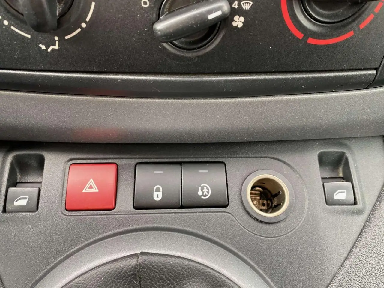 Gros plan sur la console centrale du Peugeot Partner 2017 avec boutons de verrouillage et allumage des feux de détresse.