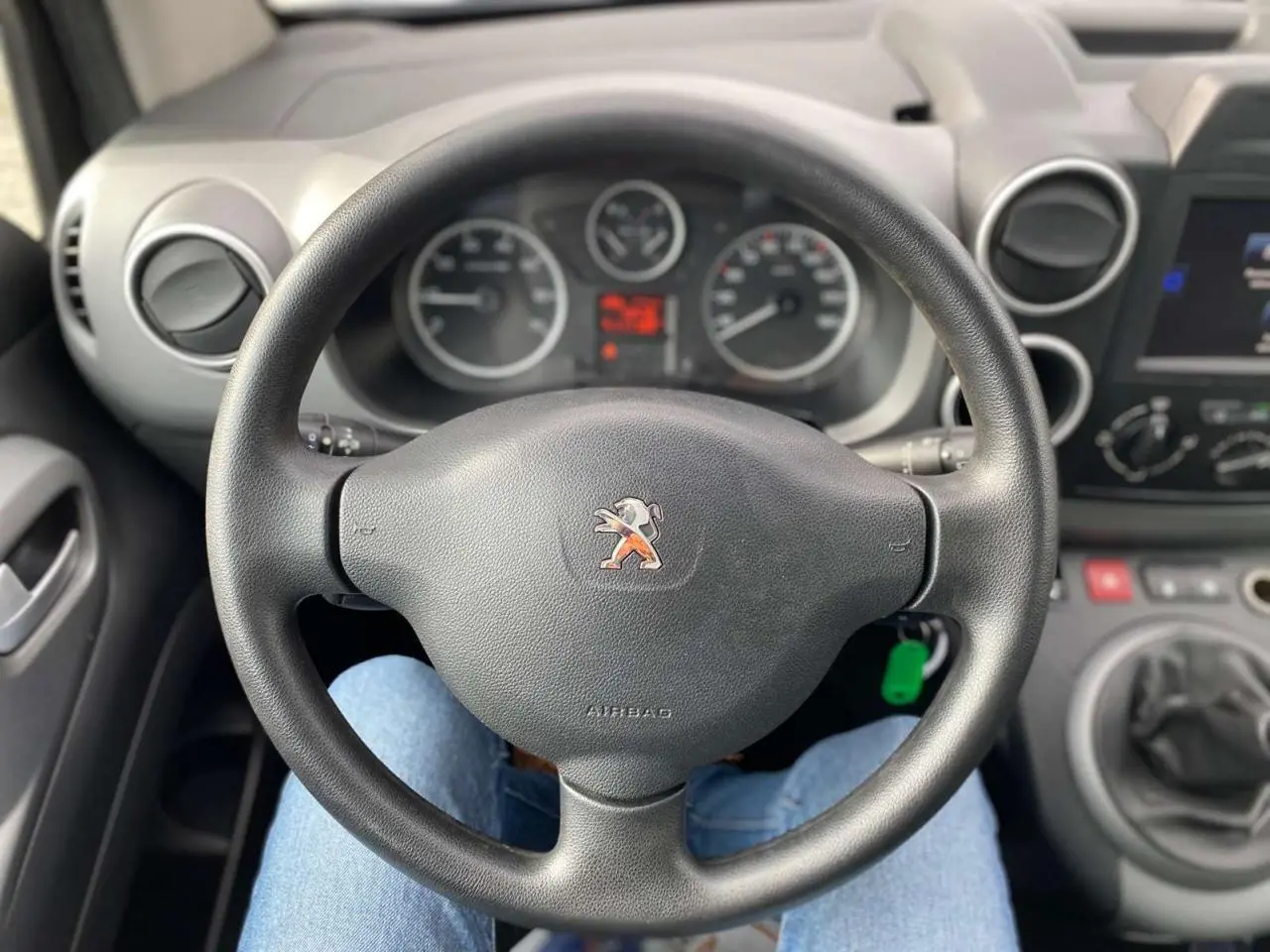 Vue rapprochée du volant noir de la Peugeot Partner 2017 avec tableau de bord et levier de vitesses manuelle visibles.