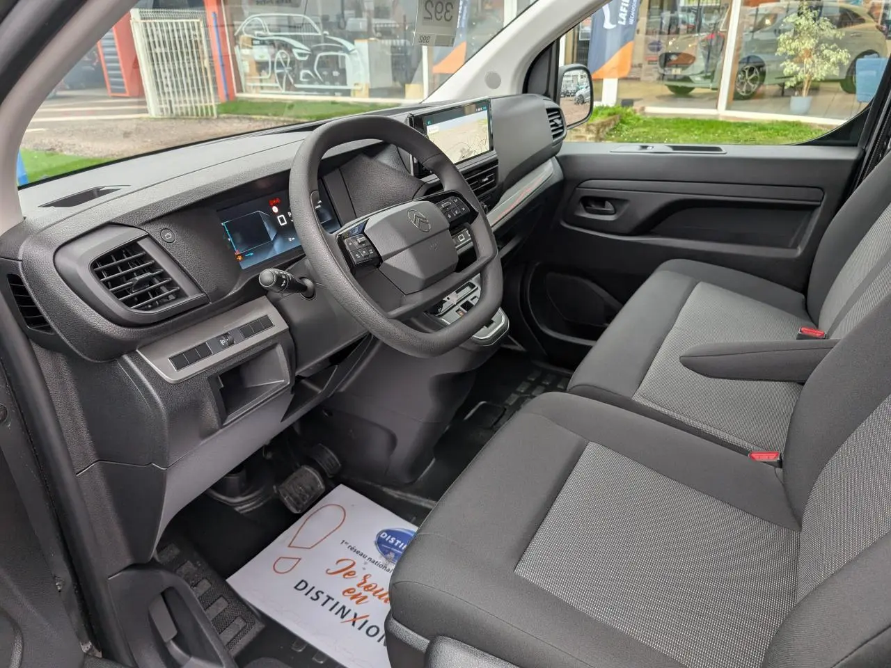 Intérieur côté conducteur du Citroën Jumpy gris 2025 avec tableau de bord moderne et sièges tissu bi-ton noir et gris