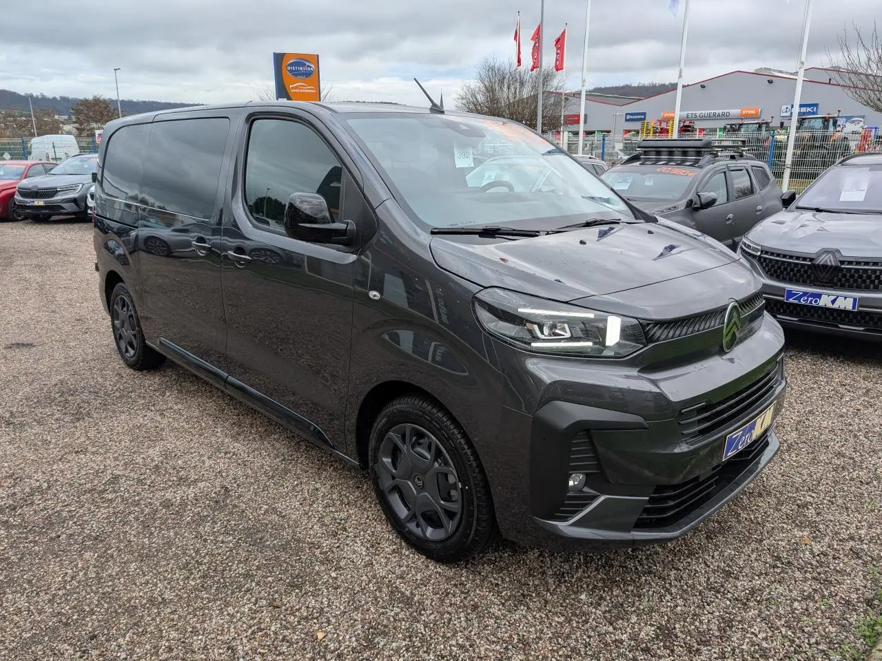 Vue 3/4 avant droit d'un Citroën Jumpy gris avec boucliers couleur carrosserie et coques de rétroviseurs noires Perla Nera.
