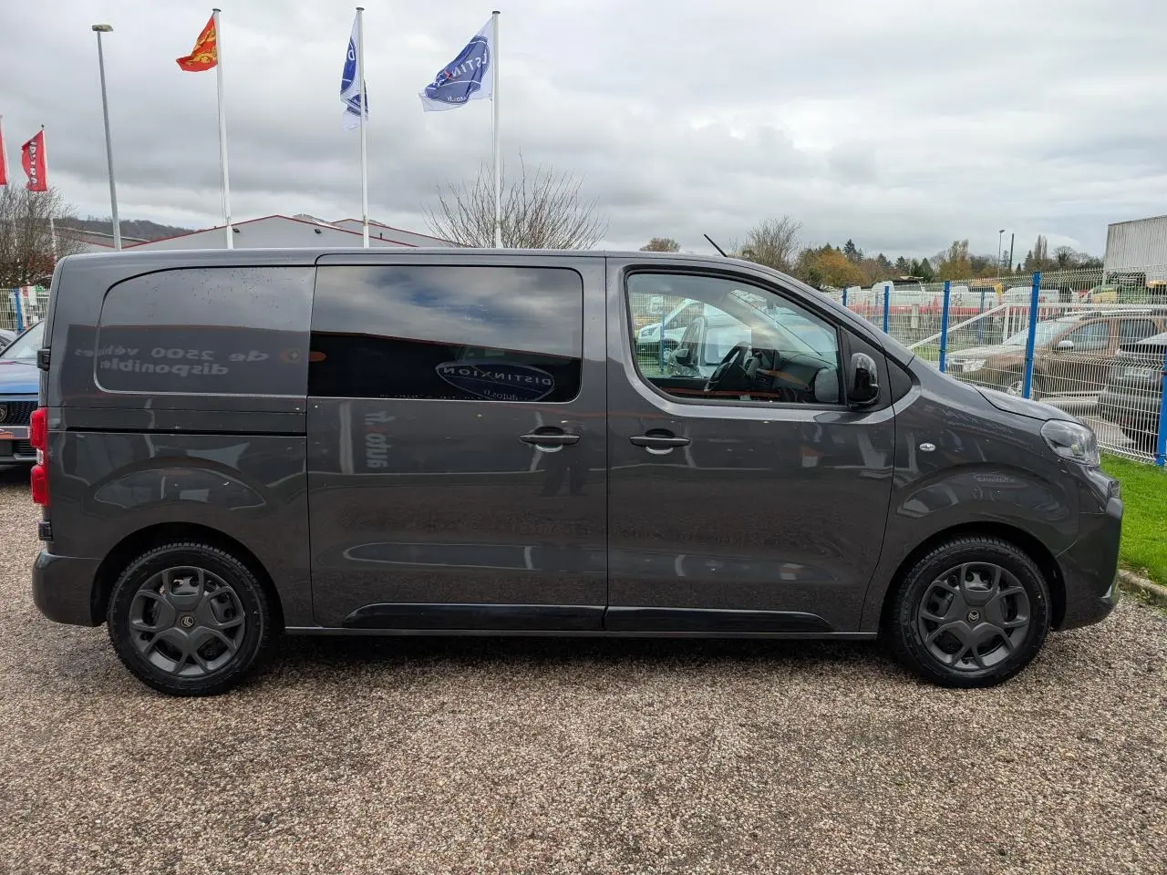 Profil côté droit d'un utilitaire Citroën Jumpy gris 2025 avec portes coulissantes et vitres teintées.