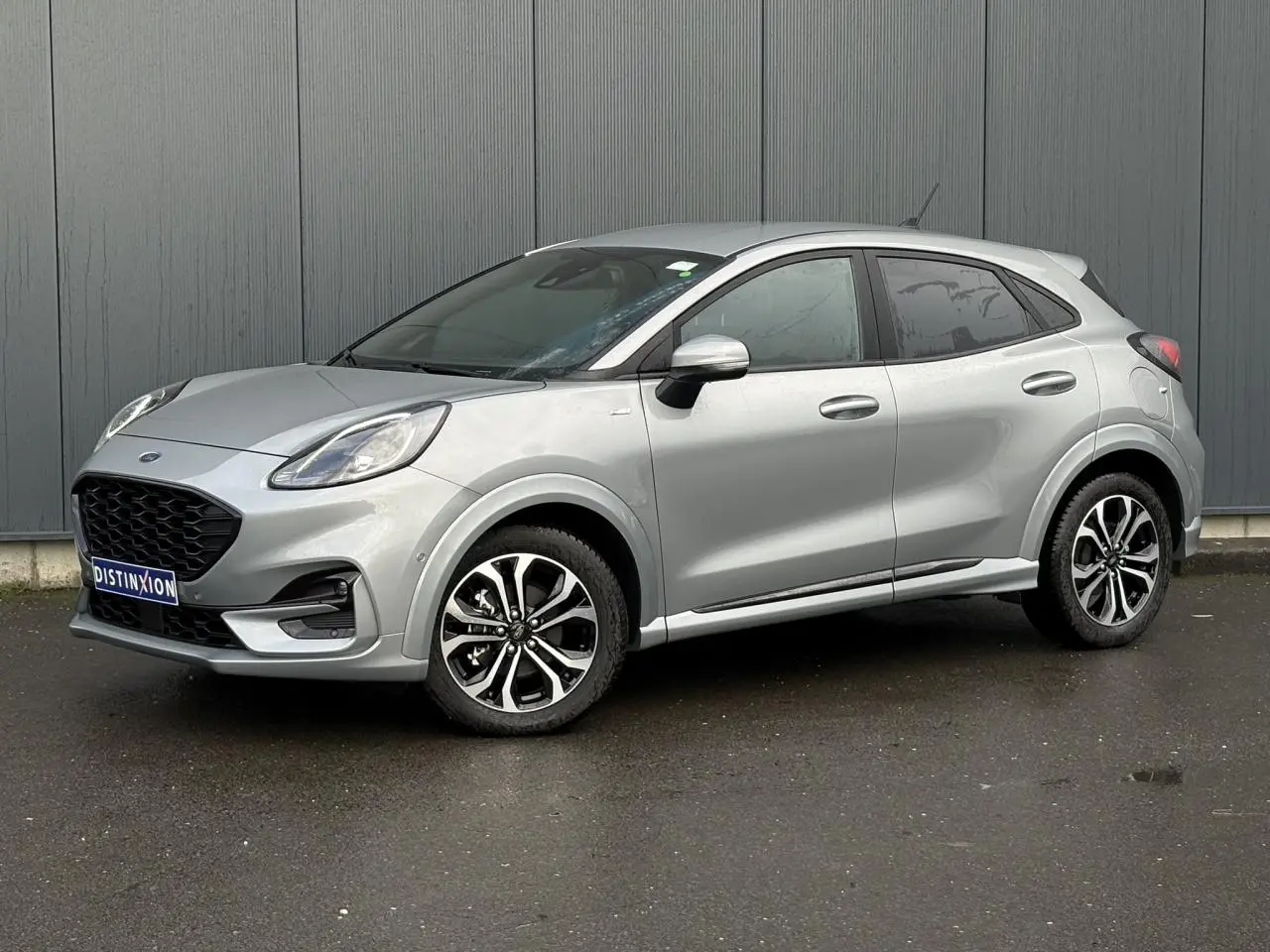 Vue 3/4 avant droit d'un Ford Puma gris Solar avec jantes alliage 17 pouces et vitres surteintées.