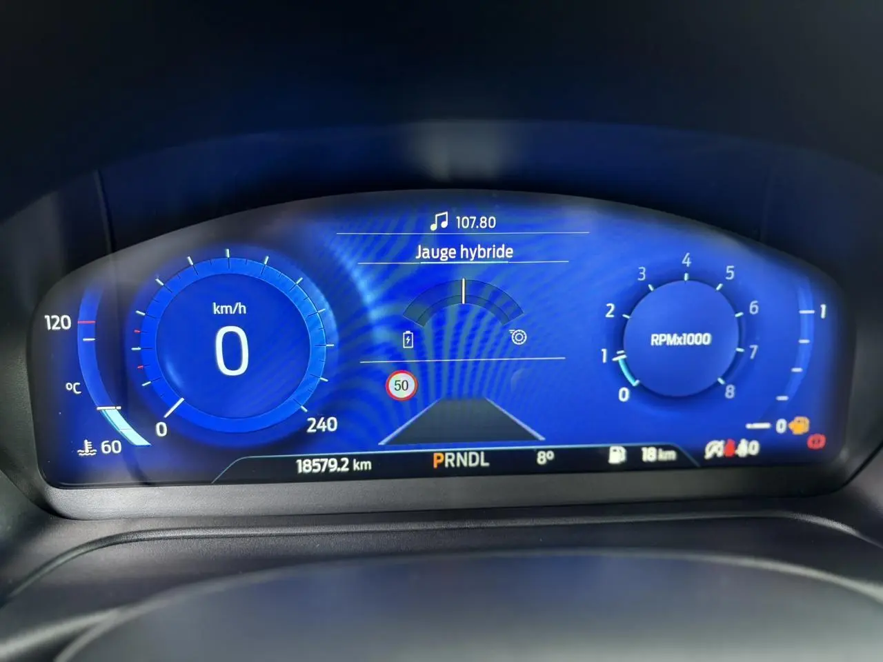 Tableau de bord numérique bleu du Ford Puma 2023, affichant la jauge hybride et compte-tours à 0 RPM.