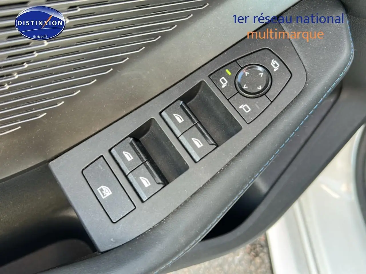 Détail des commandes des vitres et rétroviseurs sur la porte côté gauche d'une BMW Série 1 blanche Alpine.