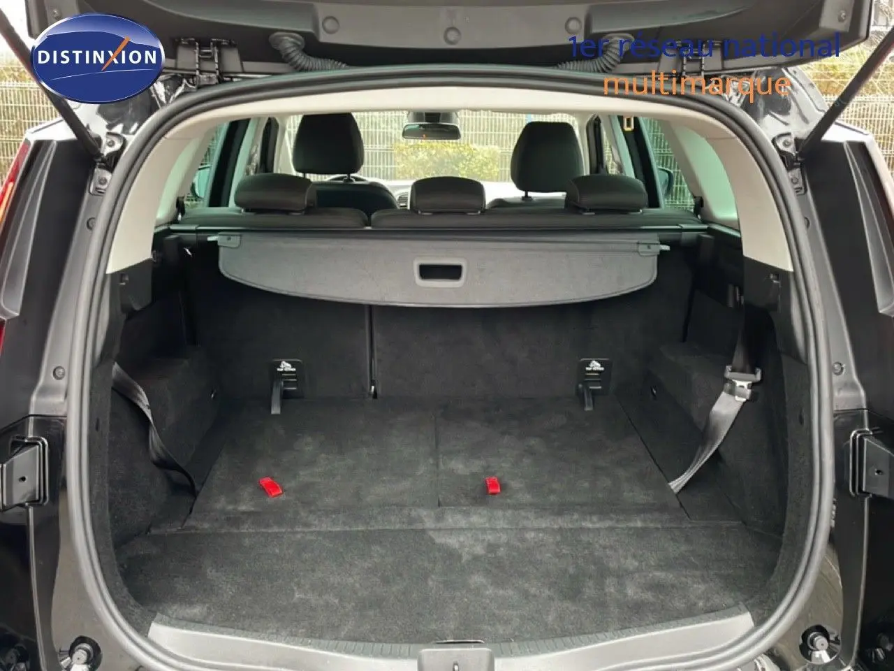 Coffre ouvert du Renault Grand Scénic noir étoile métal, vue arrière montrant l’espace de chargement et la tablette cache-bagages.