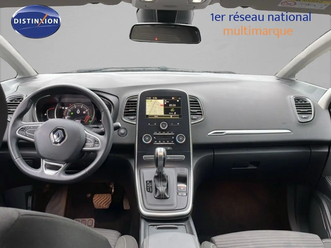 Vue intérieure avant du tableau de bord et volant noir du Renault Grand Scenic 2022 avec écran central tactile et levier de boîte automatique.